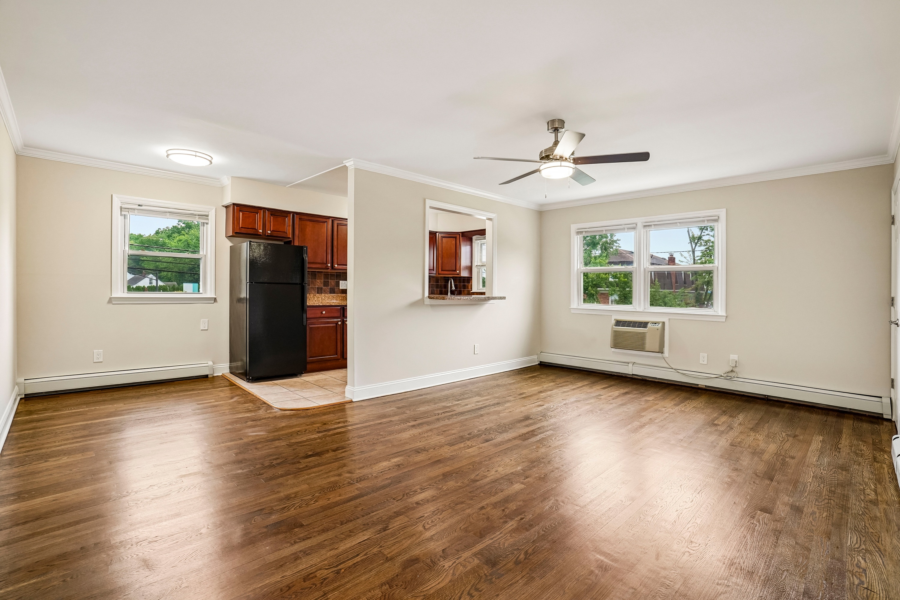 A room with a ceiling fan and wooden floors.